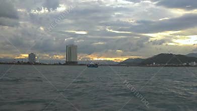 Atmospheric view of clouds and sunrise skies over buildings and mountains.