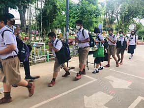 Trang, Thailand - August 6, 2020 : Young students from Banyantakhao school wear surgical face mask to protect covid-19 pay respect