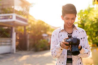 Happy young handsome Indian teenage boy in the streets outdoors