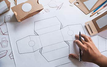 Designer sketching drawing design Brown craft cardboard paper product eco packaging mockup box development template package