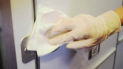 Close up female hand wiping aircraft lavatory door knob, cleaning habit, bacteria on airplane restroom door, corona virus covid19,