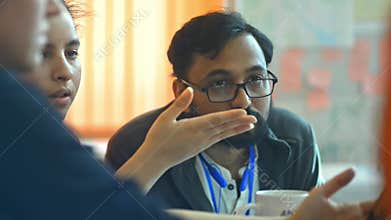 Bearded man office worker nods, listens to colleagues at conference corporate discussion irrl