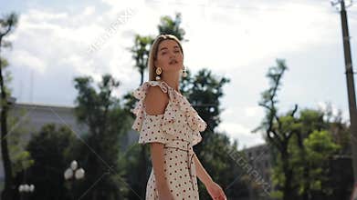 Slowmotion of beautiful elegant woman in dress walking at summer city