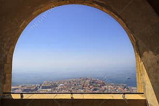 Panoramic view of the city of Naples through the arch of the medieval fortress Castel Sant`Elmo. Skyline and Gulf of Naples, Campa