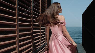 Elegant Girl In Prom Dress Is Posing Near Seaside Hotel Building On Happy Summer Day.