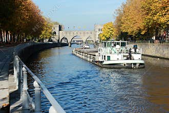 Promenade le long du quai Notre-Dame à Tournai en Belgique en automne avec le Pont des trous en perspective