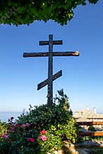 Huge wooden Orthodox eight-pointed cross against the sky after the dawn on Mount Athos