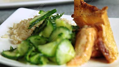 Woman food styling and cooking salmon fish with rice and cucumber