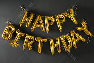 Phrase HAPPY BIRTHDAY made of golden balloon letters