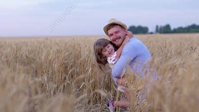 Family relationships, happy man cheerfully hugs little joyful girl and smile on field with ripe wheat during mature