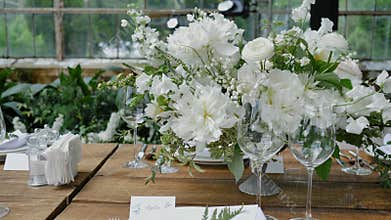 Decorating wooden tables with Bouquets of fresh Flowers with candles and Decor for a Wedding or a party for a family