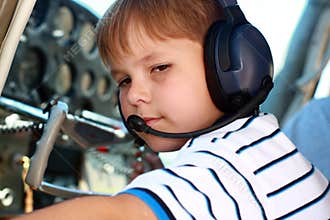 Small boy playing pilot in airplane