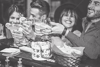 Happy friends cheering with cocktail in a vintage bar - Young people having fun toasting glasses of cocktails in a pub club