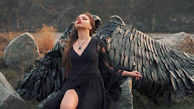 Angel of death gathers with forces to start war, girl in black long vintage dress with lace sleeves alone beside large