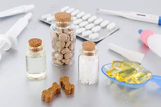 Various medical products for animal, natural supplement, oil, medicine and treats like bones on gray background