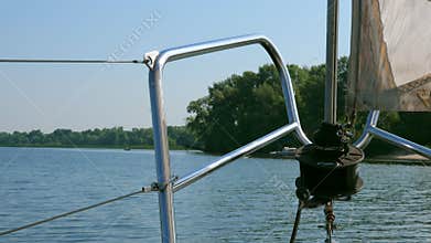 View from bow of sailing boat ashore. Summer river.