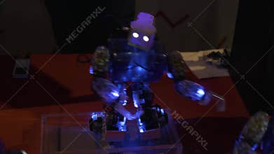 The robot dances, waving his hands in different directions