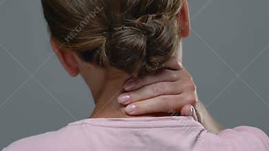 Back view of woman massaging painful neck, feeling strong ache, health problem