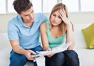 Worried woman looking at bills with her boyfriend