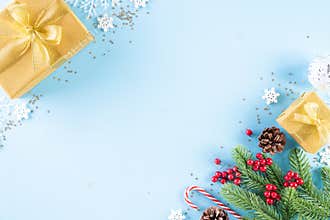Christmas background concept. Top view of Christmas golden gift box with candy cane decoration, spruce branches, star, red berries