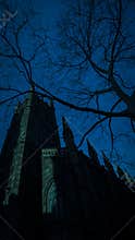 Spooky scary haunted Halloween church and tree silhouette at night