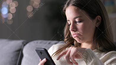 Bored woman reading phone content in the night