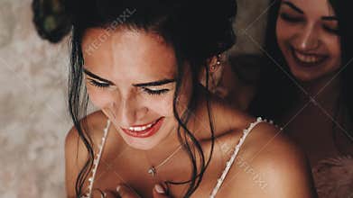 A beautiful dark-haired girl laughs merrily with her friend. Nice smile.