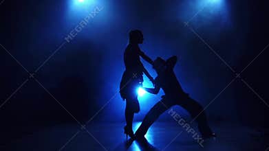 Silhouette of pair dancers performing modern dance in slow motion