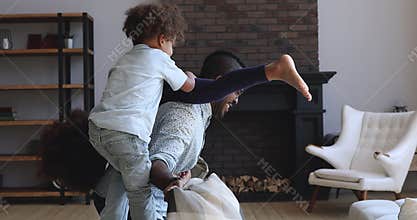 Happy african dad having fun with active kids at home