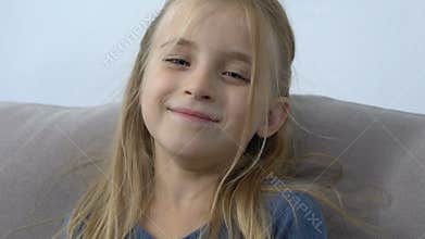 Adorable caucasian girl sending air kiss on camera, sincere childhood emotions