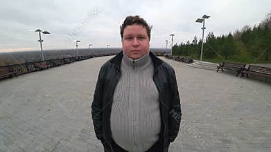 Wide angle lens: young fat man looking at camera, smiling and nods his head YES