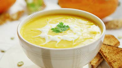 Pumpkin soup in bowl served with bread