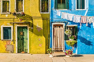 Typical colorful house of Burano Island with hanging laundry at its facade