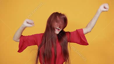 Red lady who is very charming is enjoying the music by dancing around.