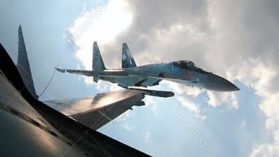 Military aircraft pursues enemy target. Su-35 motor is smoking, plane is evading