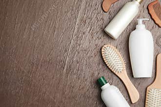 Flat lay composition with hair cosmetic products and tools on brown background
