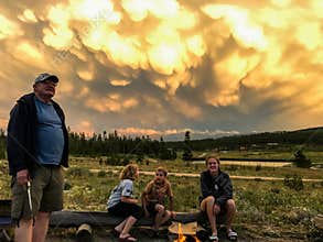 Grandpa with Grandchildren Looking at Stunning Stormy Sunset Clouds