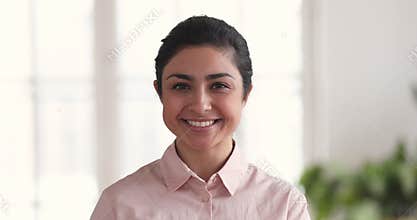 Closeup portrait of smiling millennial indian business woman in office