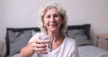 Happy healthy older woman recommending fresh mineral pure water