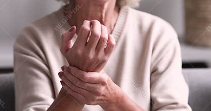 Senior grandmother massaging hand suffering from rheumatoid arthritis