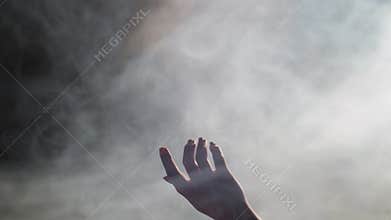 Young dancer making hand movement in smoky studio