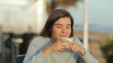 Happy girl smelling coffee aroma in slow motion