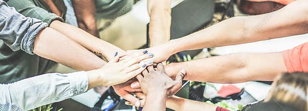 Work team stacking hands together for new startup project - Diverse culture people giving strength motivation to each others -