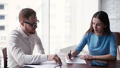 Young woman boss ends explanation and makes note on paper in boardroom