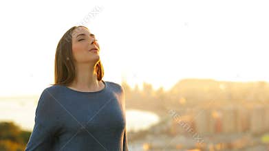 Woman relaxing breathing fresh air in city outskirts