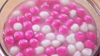Boiling Tang yuan, tangyuan, delicious red and white rice dumpling balls in a glass pot. Concept of cooking at home for Winter Sol