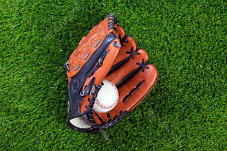 Baseball glove and ball on grass