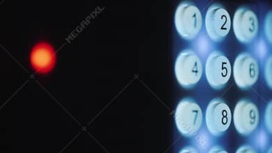 A person enters a pin code on a backlit keyboard