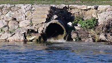Polluted waters drain into the waters of the river.