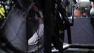Close-up legs of athletic man scrolling the pedal on the exercise bike.